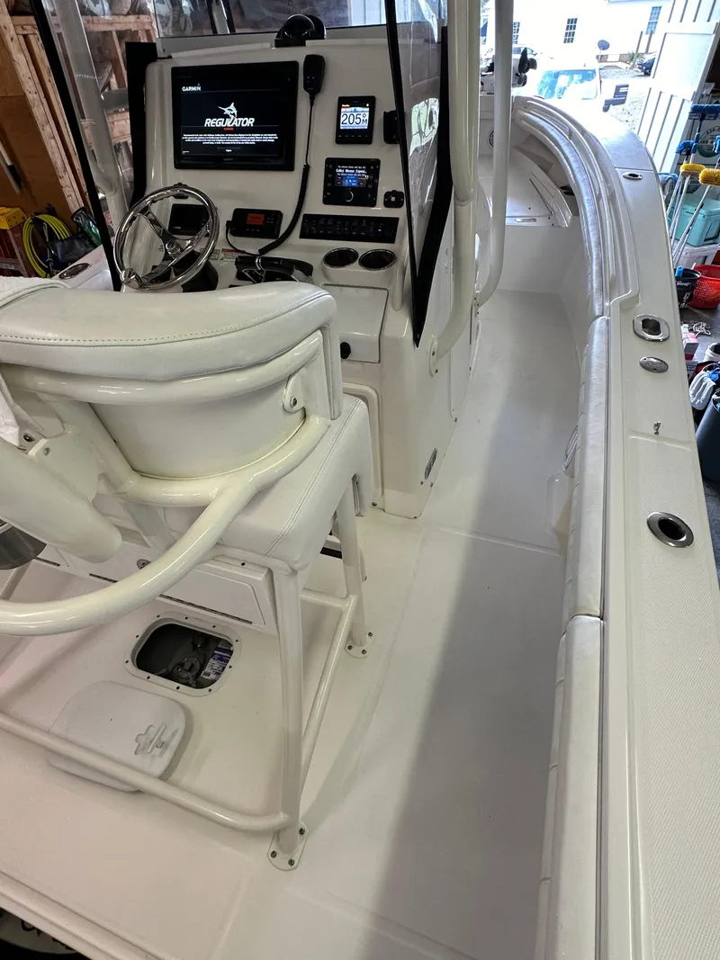 Slide: The Image of 2019 Regulator 23 FS boat interior with helm, seating, and navigation equipment. - 26