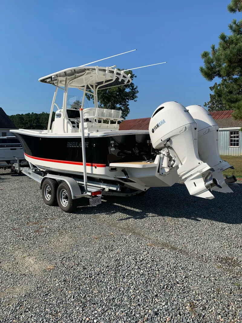Slide: The Image of 2019 Regulator 23 FS boat on trailer with Yamaha engines, parked outdoors. - 3