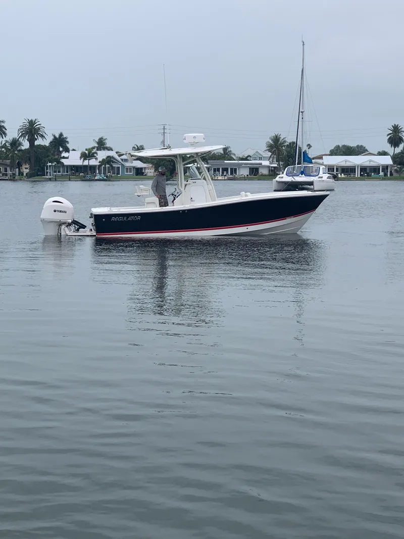 Slide: The Image of 2019 Regulator 23 FS boat on calm water with palm trees in background. - 8