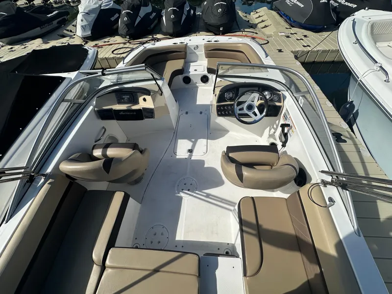 Slide: The Image of 2019 Hurricane SD191 boat interior with beige seating and dual consoles at a dock. - 8