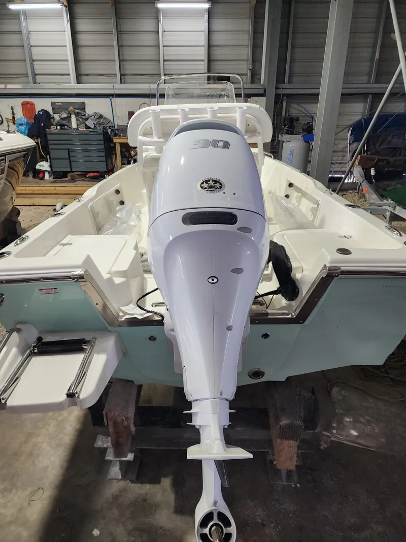 Slide: The Image of 2025 Key West 1720 Center Console boat with powerful outboard motor in a garage setting. - 4
