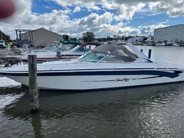 The Image of 1996 Sea Ray 380 Sun Sport boat docked at marina under cloudy sky. - 1