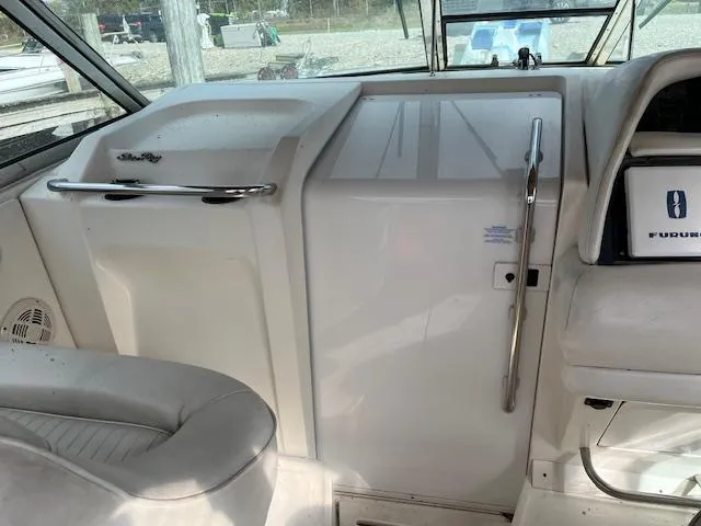 Slide: The Image of Interior of a 1996 Sea Ray 380 Sun Sport boat cockpit, featuring white seating and control panel. - 10