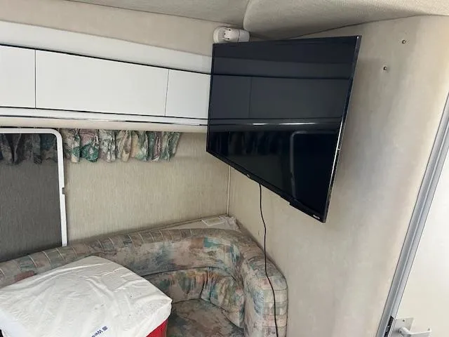 Slide: The Image of Interior of 1996 Sea Ray 380 Sun Sport with mounted TV and patterned seating. - 13