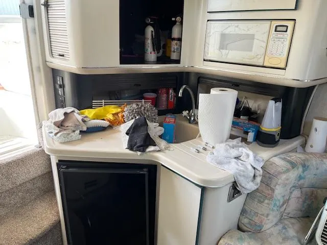 Slide: The Image of Interior of 1996 Sea Ray 380 Sun Sport boat with kitchenette and cluttered counter. - 14