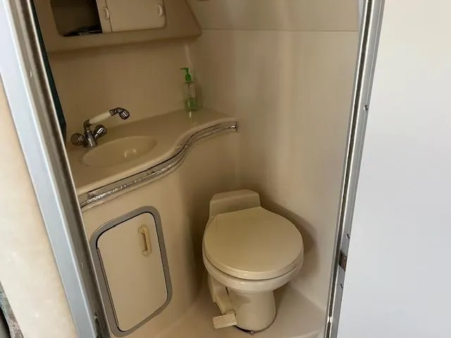 Slide: The Image of Compact bathroom in a 1996 Sea Ray 380 Sun Sport boat, featuring a sink and toilet. - 15