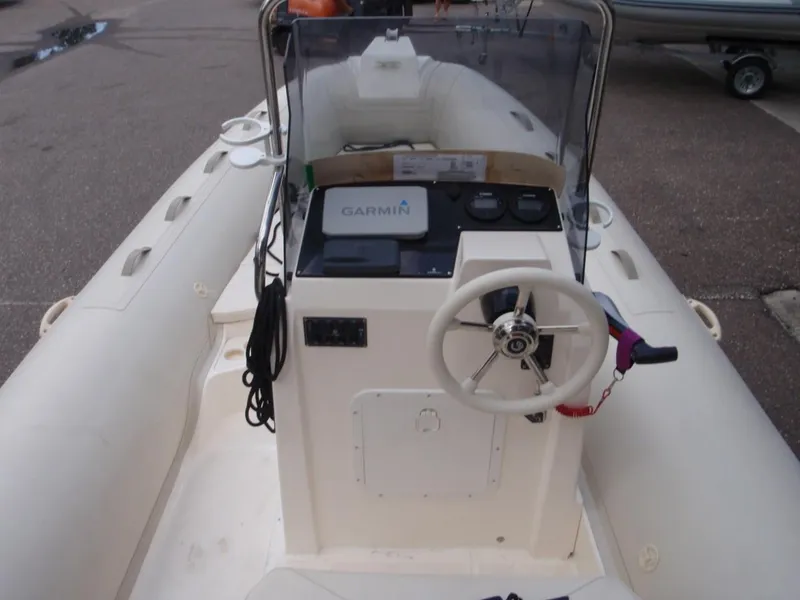 Slide: The Image of 2016 Capelli Tempest 570 boat interior with steering wheel and Garmin navigation system. - 13