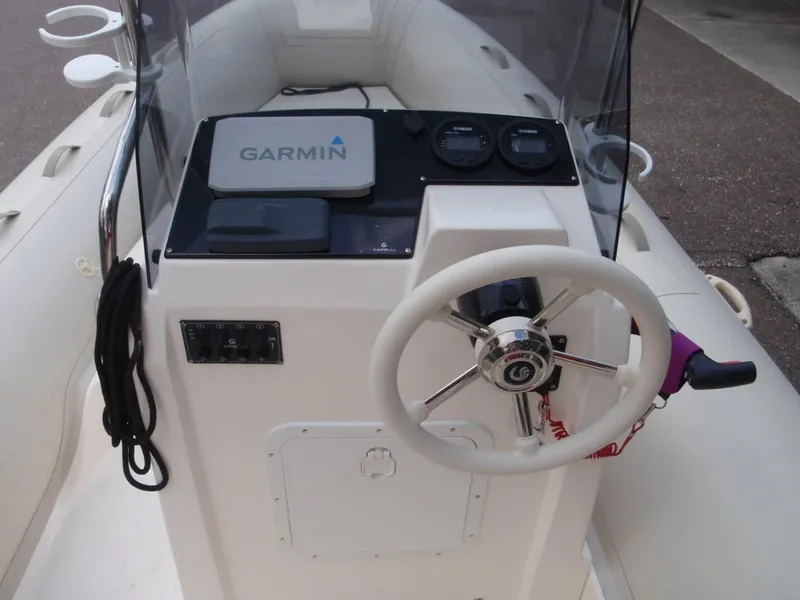 Slide: The Image of 2016 Capelli Tempest 570 boat dashboard with Garmin navigation system and steering wheel. - 14