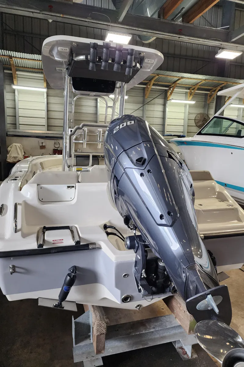 Slide: The Image of 2025 Key West 219 FS boat with powerful outboard motor in a storage facility. - 6