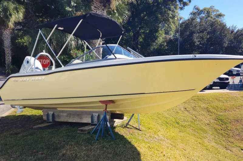 Slide: The Image of 2025 Key West 203 DFS boat on display, yellow hull, black canopy, outdoor setting. - 0