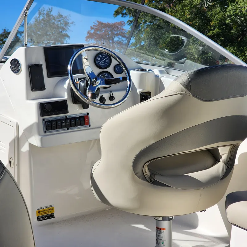 Slide: The Image of 2025 Key West 203 DFS boat interior with steering wheel and dashboard controls. - 12