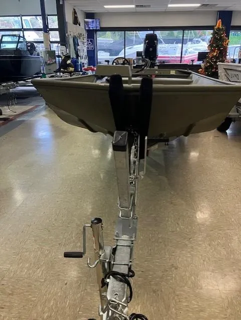 Slide: The Image of 2024 Lund 1852MT boat interior in showroom, featuring steering wheel and equipment. - 5