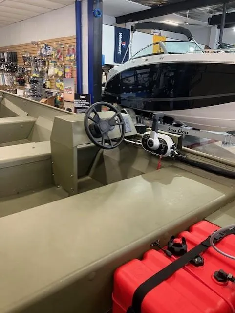 Slide: The Image of 2024 Lund 1852MT boat interior with steering wheel and equipment in showroom. - 6