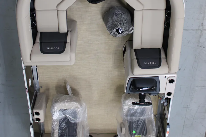 Slide: The Image of 2025 Harris Cruiser 210 boat interior with beige seating and steering console. - 3