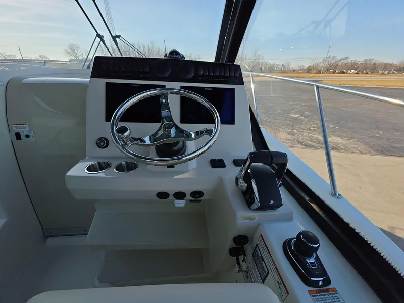 Slide: The Image of Helm of 2025 Boston Whaler 325 Conquest boat with steering wheel and controls. - 13