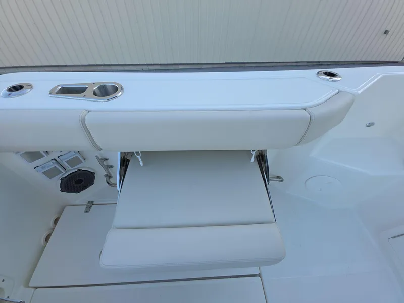 Slide: The Image of Boston Whaler 325 Conquest 2025 boat seating area with foldable bench and cup holders. - 18