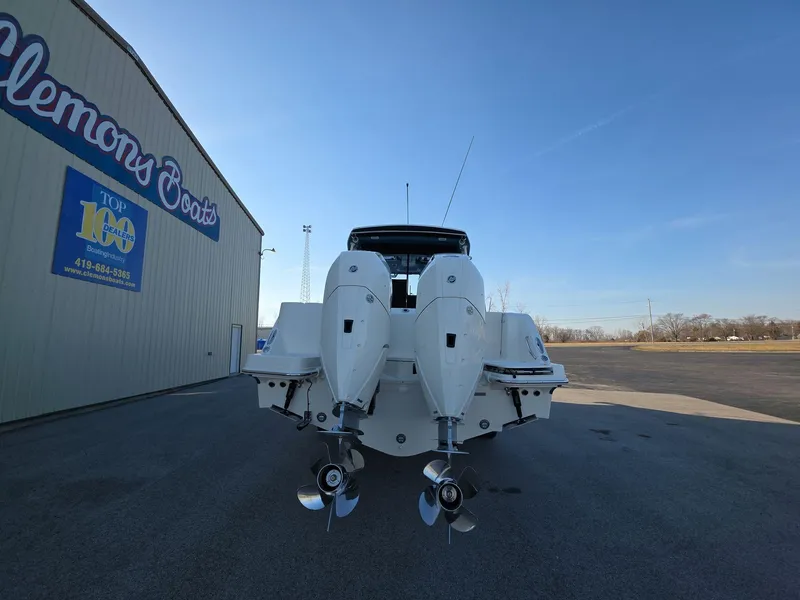 Slide: The Image of 2025 Boston Whaler 325 Conquest boat with dual engines, parked outside a boat dealership. - 5