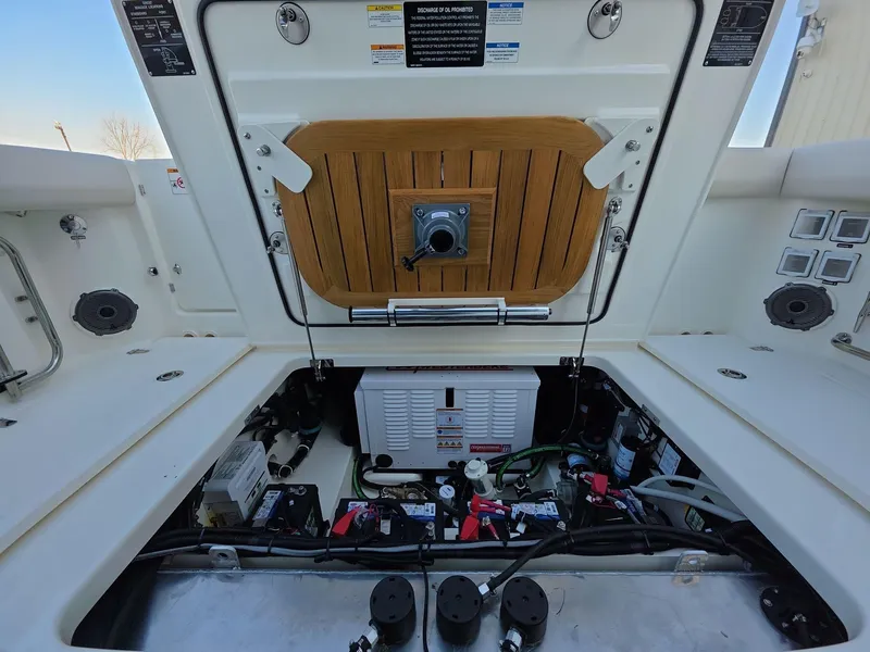Slide: The Image of 2025 Boston Whaler 325 Conquest engine compartment with open hatch and visible components. - 7