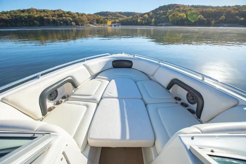 Slide: The Image of 2006 Crownline 270 BR boat interior with white seating on a serene lake. - 12