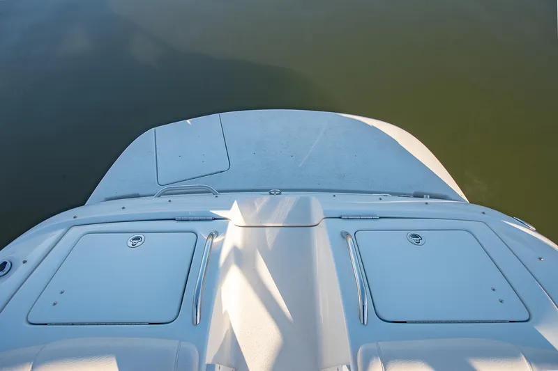 Slide: The Image of 2006 Crownline 270 BR boat deck, featuring storage compartments, on calm water. - 26
