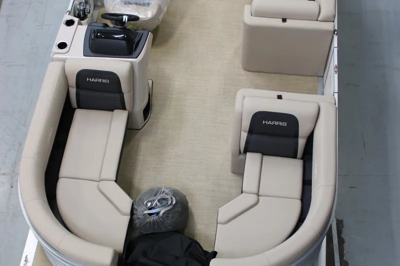 Slide: The Image of 2024 Harris Cruiser 190 pontoon boat interior with beige seating and black accents. - 2