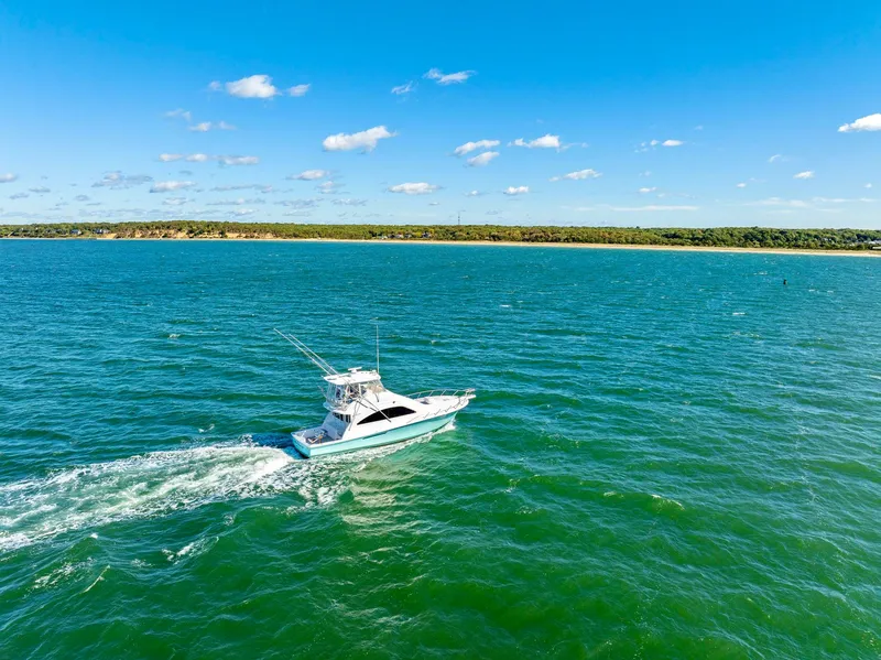 Slide: The Image of 2005 Ocean Yachts 50 Super Sport cruising on open water under a clear blue sky. - 12