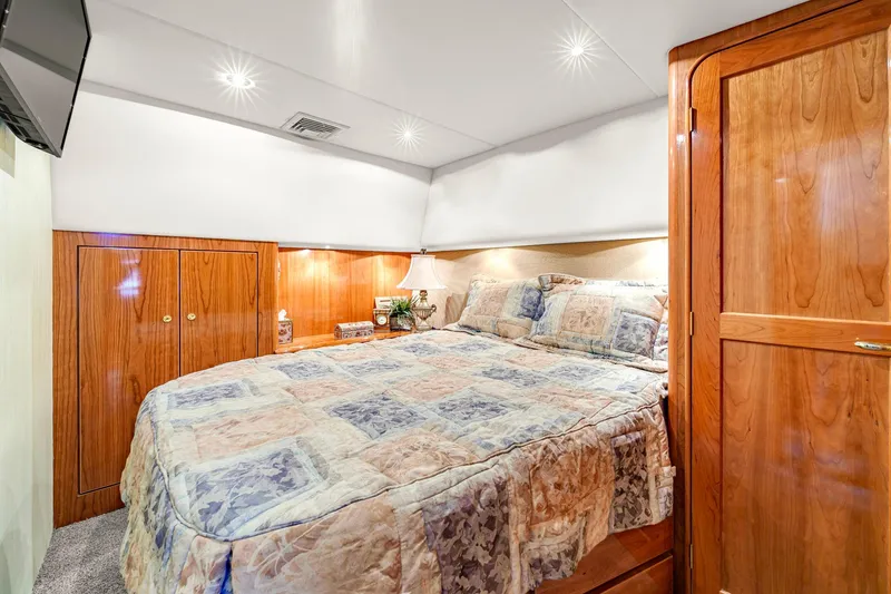 Slide: The Image of Luxurious bedroom interior of 2005 Ocean Yachts 50 Super Sport with wood cabinetry and cozy bedding. - 29