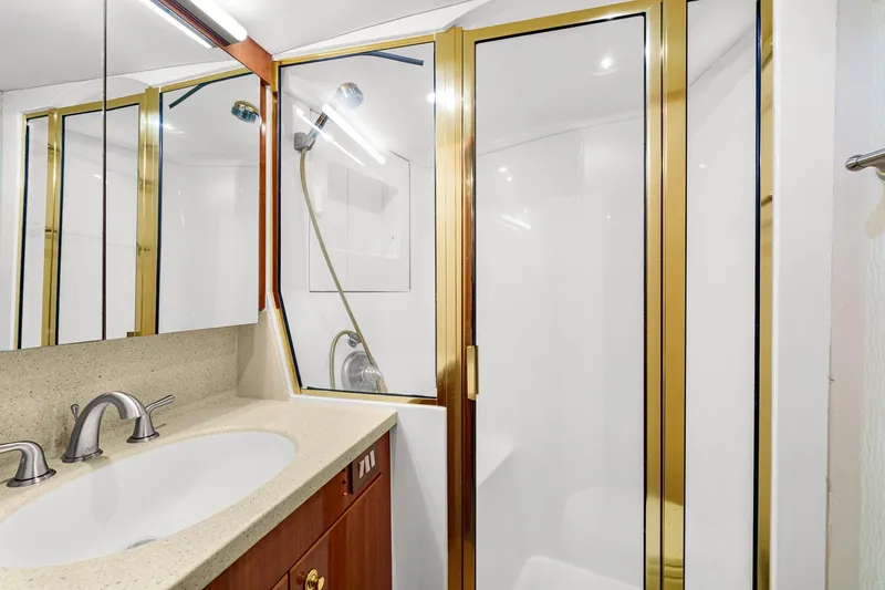 Slide: The Image of Luxurious bathroom in 2005 Ocean Yachts 50 Super Sport with gold accents and modern fixtures. - 30
