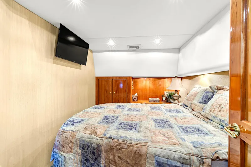 Slide: The Image of Luxurious bedroom in 2005 Ocean Yachts 50 Super Sport with cozy bedding and wall-mounted TV. - 31