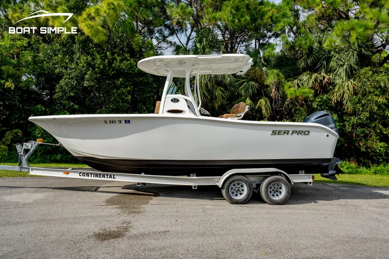 Slide: The Image of 2024 Sea Pro 239 Deep V CC boat on trailer, surrounded by trees. - 0