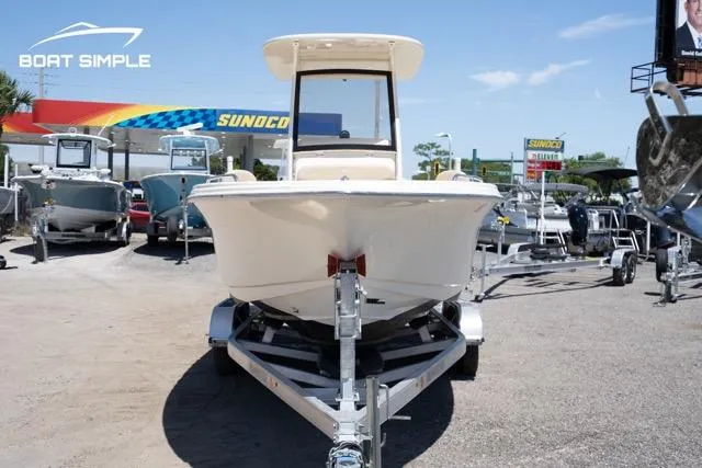 Slide: The Image of 2023 Scout 215 XSF boat on trailer at dealership, sunny day. - 2