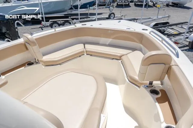 Slide: The Image of 2023 Scout 215 XSF boat interior with beige seating and cup holders. - 6