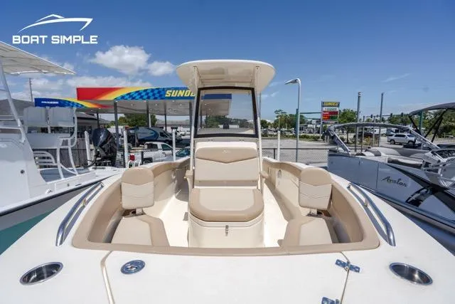 Slide: The Image of 2023 Scout 215 XSF boat with beige seating, displayed at a dealership. - 9