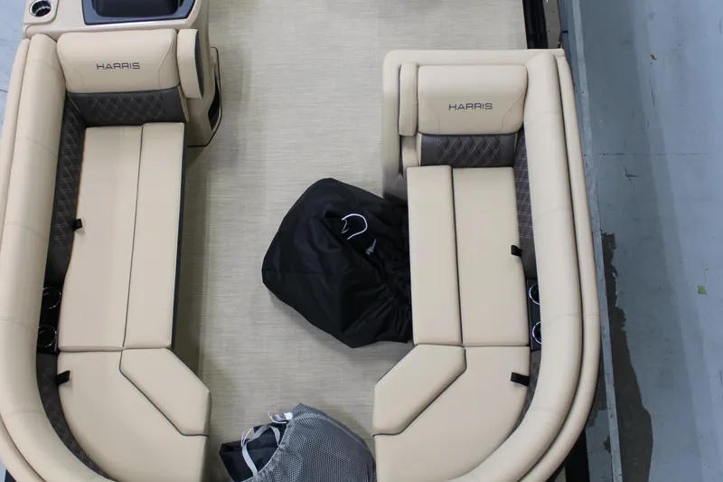 Slide: The Image of 2025 Harris Sunliner 230 boat interior with beige seating and storage bag. - 3