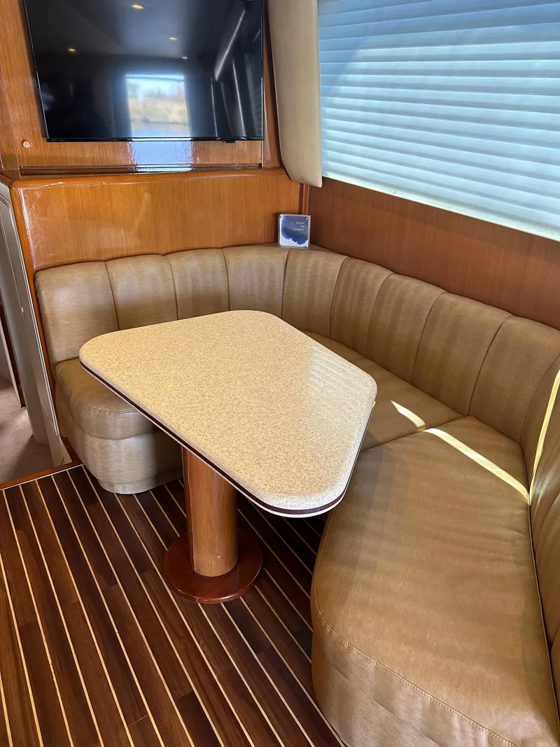 Slide: The Image of 1999 Viking 55 Convertible yacht with spacious deck and ladder, docked at marina. - 11