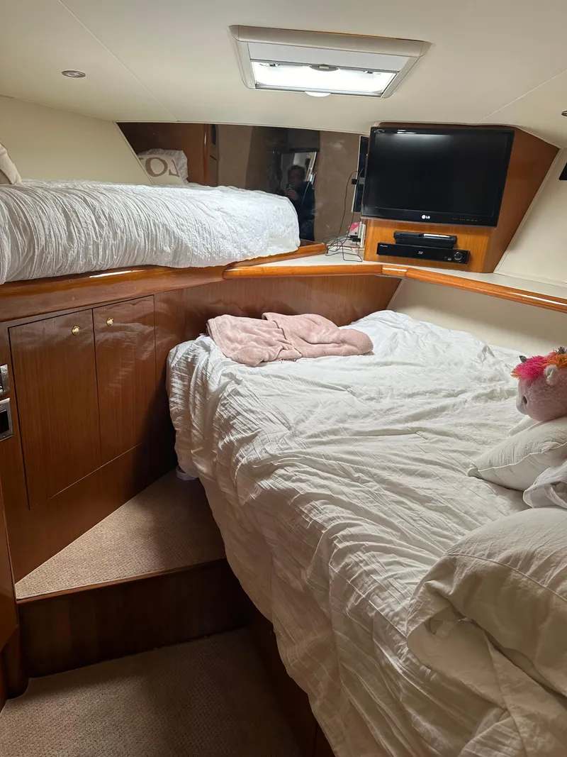 Slide: The Image of Luxurious interior of 1999 Viking 55 Convertible yacht with beige leather seating and wooden table. - 15