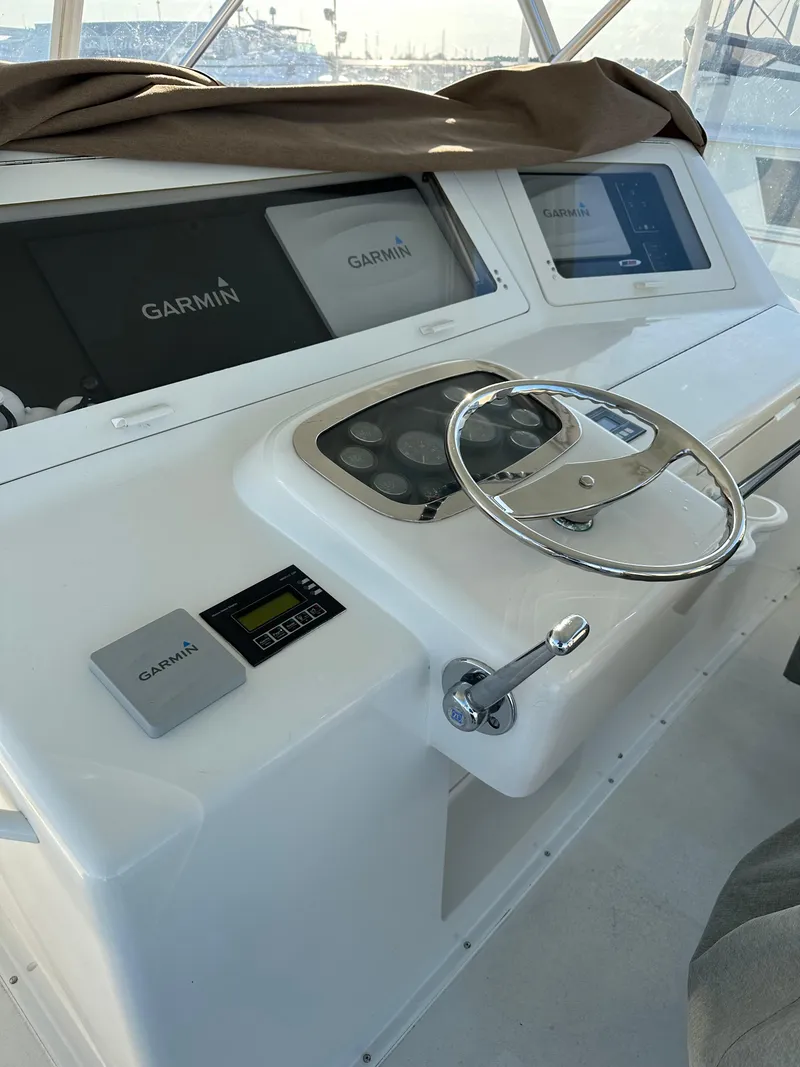 Slide: The Image of 1999 Viking 55 Convertible yacht helm with Garmin navigation displays and steering wheel. - 28