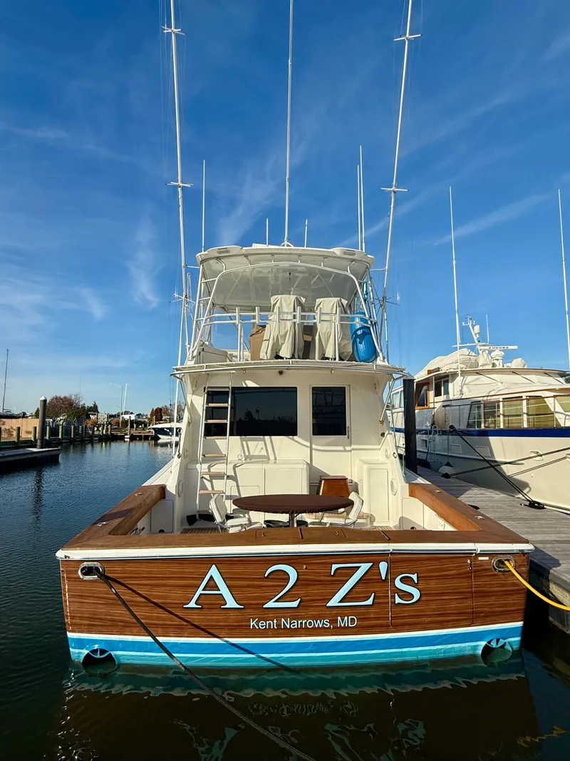 Slide: The Image of 1999 Viking 55 Convertible yacht docked in marina, blue hull, clear sky. - 3