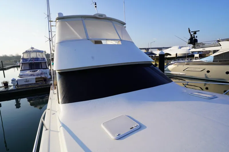 Slide: The Image of 1999 Viking 55 Convertible yacht docked at marina under clear blue sky. - 37