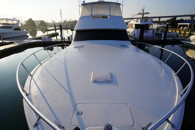Slide: The Image of 1999 Viking 55 Convertible yacht docked at marina, viewed from bow. - 38