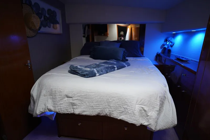 Slide: The Image of Luxurious bedroom interior of 1999 Viking 55 Convertible yacht with ambient blue lighting. - 41