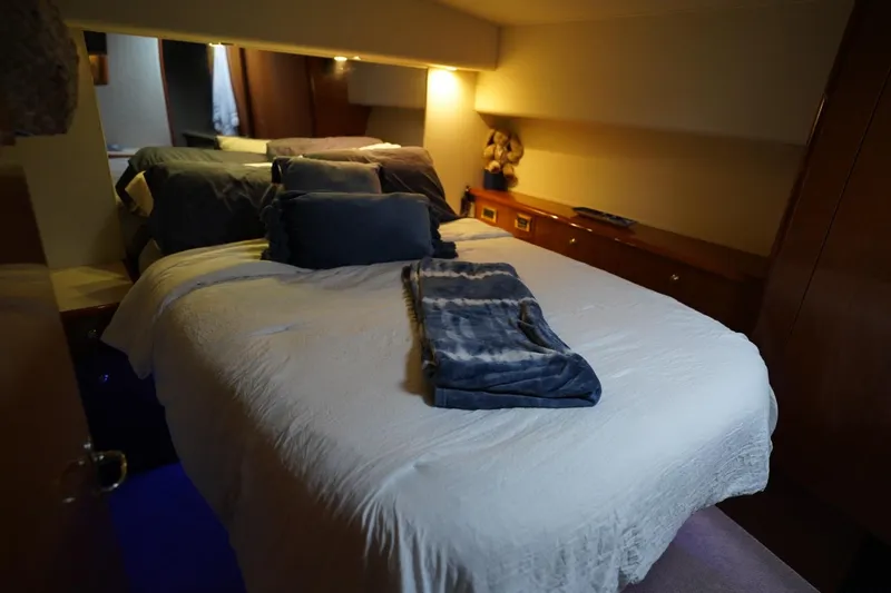 Slide: The Image of Cozy bedroom interior of 1999 Viking 55 Convertible yacht with plush bedding and soft lighting. - 42