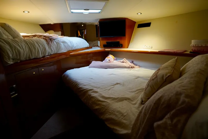 Slide: The Image of Cozy cabin interior of 1999 Viking 55 Convertible yacht with plush bedding and soft lighting. - 48