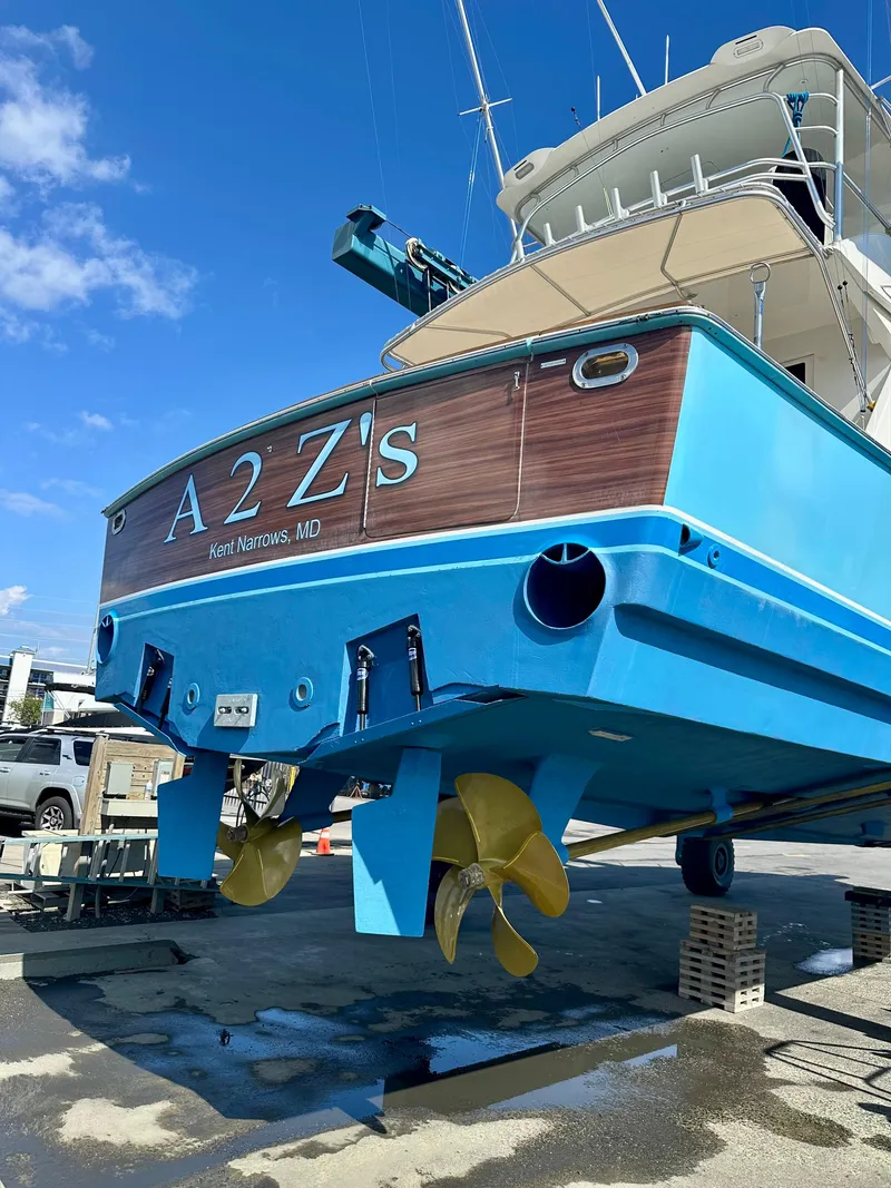 Slide: The Image of 1999 Viking 55 Convertible yacht docked at marina, featuring blue hull and covered deck. - 5