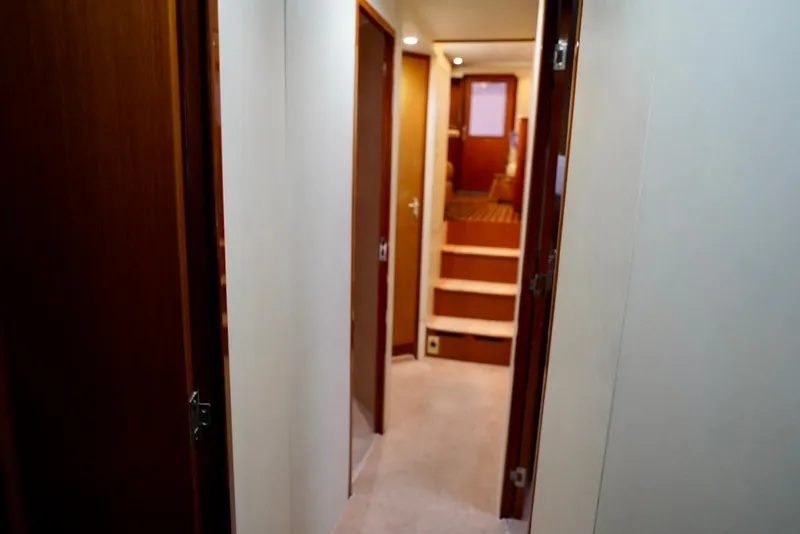 Slide: The Image of Interior hallway of 1999 Viking 55 Convertible yacht with wooden doors and stairs. - 52