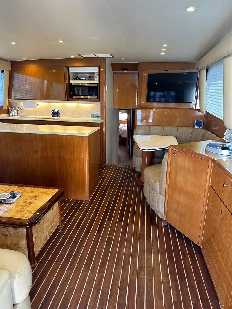 Slide: The Image of 1999 Viking 55 Convertible yacht deck with wooden flooring and seating area. - 9