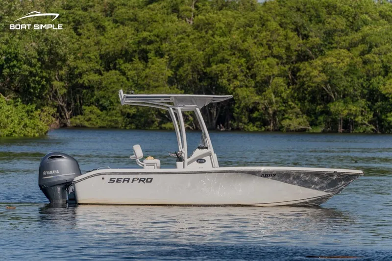 Slide: The Image of 2023 Sea Pro 199 Deep V Center Console boat on calm water, surrounded by lush greenery. - 0