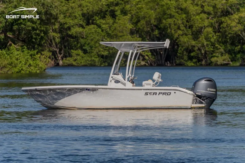 Slide: The Image of 2023 Sea Pro 199 Deep V Center Console boat on calm water, surrounded by lush greenery. - 1