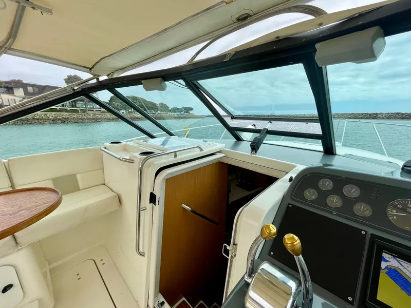 Slide: The Image of 1998 Tiara Yachts 3100 Open cockpit with steering controls and ocean view. - 16