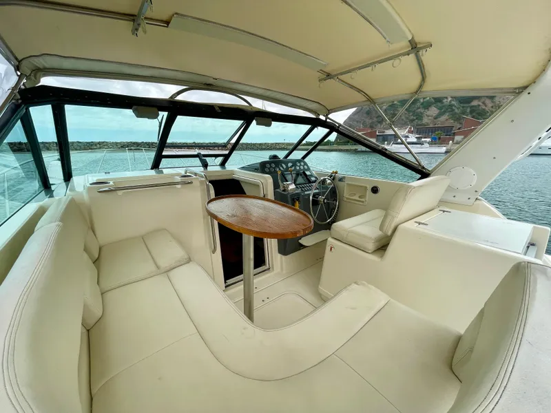 Slide: The Image of 1998 Tiara Yachts 3100 Open interior with helm, seating, and table, docked at marina. - 19